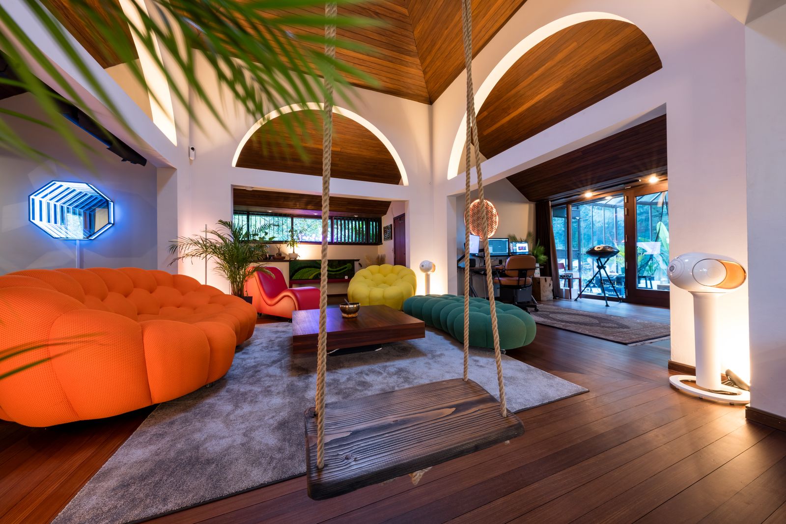 Les volumes, puis les détails Séjour contemporain à double hauteur, plafond en bois et canapé orange.